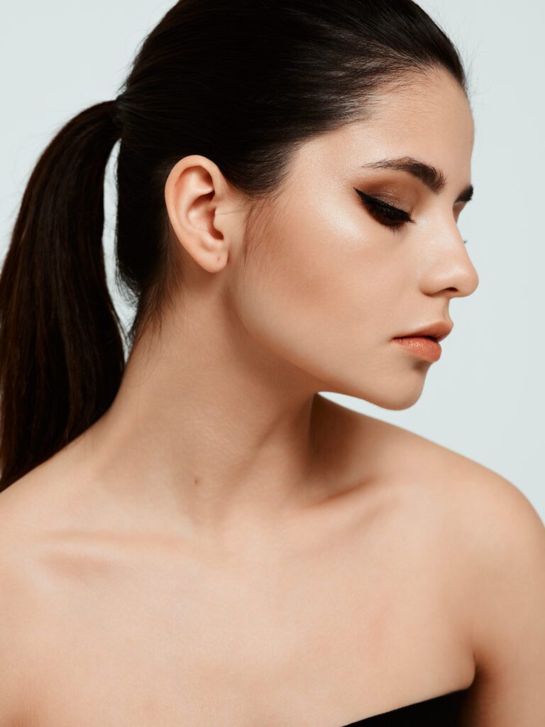 Profile of a woman with closed eyes showing ear lobe with earring hole