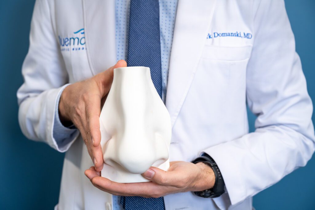 Dr. Domanski holding a mold of a nose