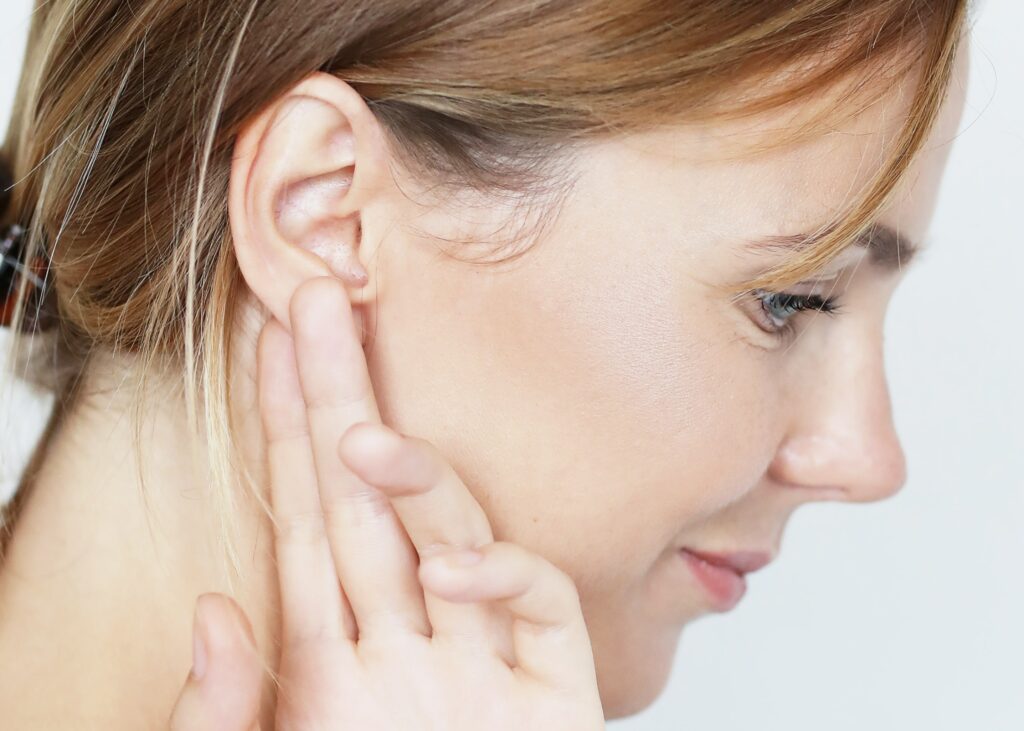 Side view of woman touching her ears