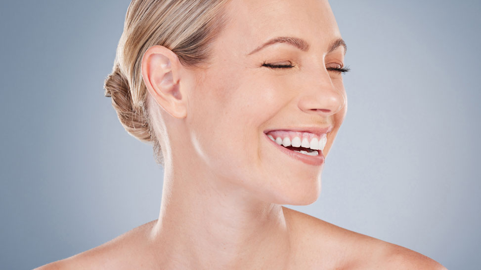 happy woman with a defined and improved neck contour, smiling with closed eyes
